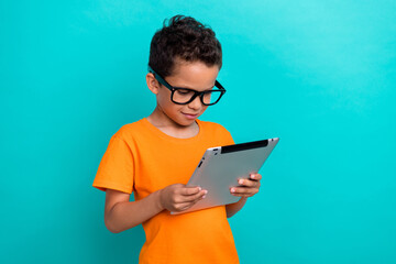 Photo of clever funky little guy dressed orange t-shirt arm typing modern gadget empty space...