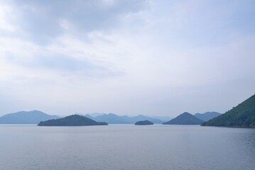 In selective focus a beautiful Kaeng Krachan dam with lake view and many hill along river side,blue sky background 