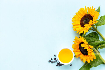 Blooming yellow sunflowers with cooking oil and black seeds, top view
