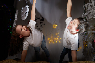 Beautiful little boy and girl in the room decorated for Christmas with big toy. Merry Christmas and Happy Holidays