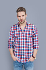 caucasian stylish guy having face stubble. stylish guy in checkered shirt isolated on grey.