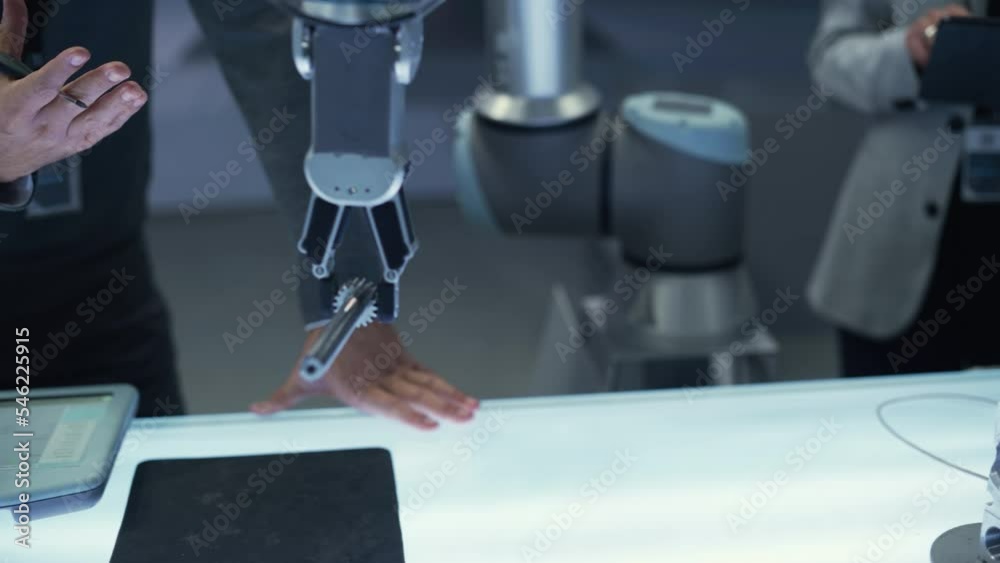 Aufkleber High Tech Robotic Arm Picking Up and Moving a Mechanical Metal Component. Chief Engineer Showcasing the Capabilities of the Robot Arm Machine. Close Up Slow Motion Follow Footage.