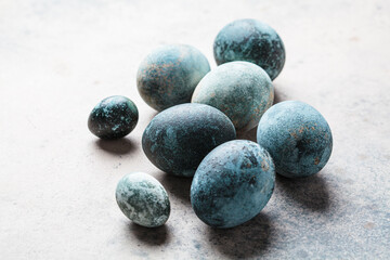 Easter eggs painted in trendy denim blue, gray background.