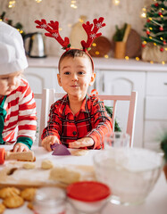happy cheerful boy cooks dough, bakes cookies in the kitchen, the concept of celebration and fun