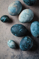 Easter eggs painted in trendy denim blue, gray background.