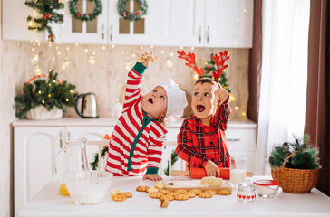 a happy family of cheerful kids cooks dough, bakes cookies in the kitchen. The concept of celebration and comfort