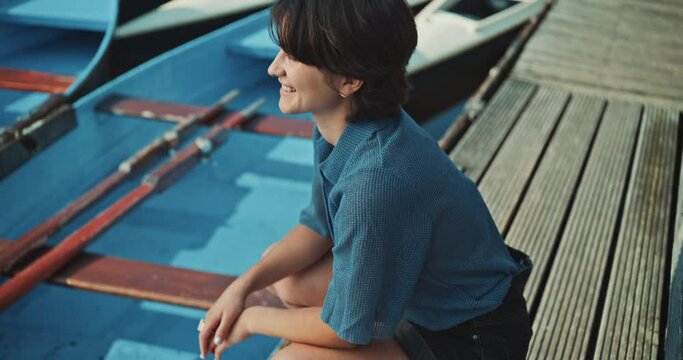 Young woman looks into the camera smiling on the dock