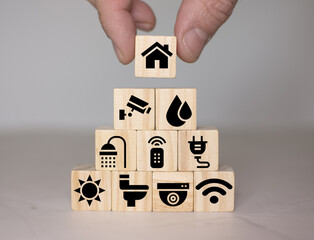 Hand holding house on wood cube. Home energy sustainable concept 