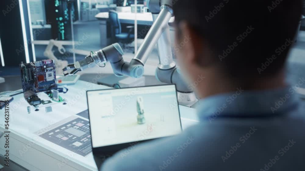 Fototapete Software Engineer Implementing Technical Application Updates to a Robotic Arm Machine on a Laptop. Machinery Operator Using Computer to Automate Tasks on the Robot Hand. Technological Startup Company.