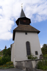 Fototapeta na wymiar Medieval church at village of Kyburg, Canton Zürich, on a blue cloudy summer day. Photo taken September 1st, 2022, Kyburg, Switzerland.