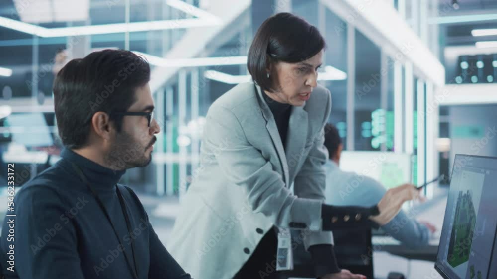 Poster Two Industrial Design Agency Specialists Discussing a 3D Circuit Board Model Created on a CAD Software on Desktop Computer. Young Man and Female Working in Electronics Development Factory.