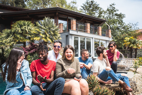 Happy Multiracial Friends On Holiday In A Luxury House Standing At The Poolside