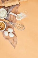 Bakery  or cooking frame, ingredients, kitchen items for pastry on pastel orange background. Top view, copy space.