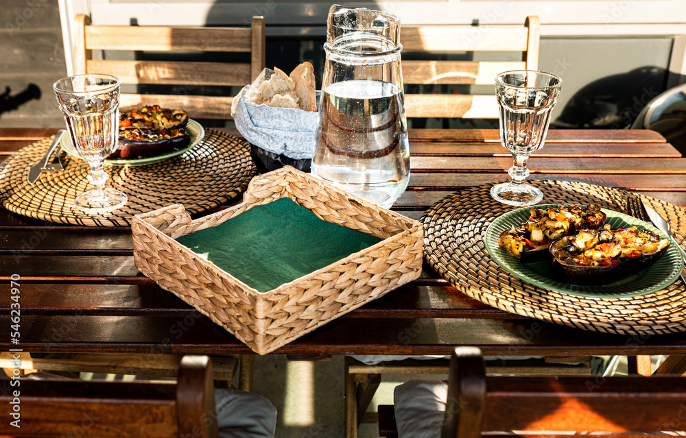 Wall mural meal with stuffed aubergines and homemade bread outdoor in the sunshine. delicious dish on rustic wo