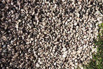 Gray stones with green grass in the corner background for decoration design.  Abstract nature flat lay, top view.