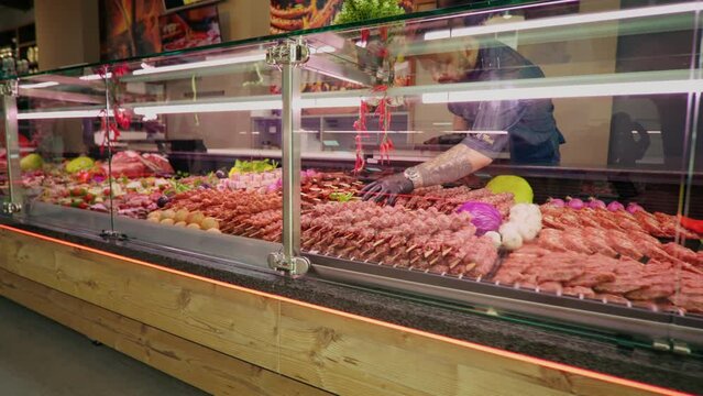 Chops of beef meat on skewers layout in the store. Selection of different cuts of fresh meat raw red in a supermarket.