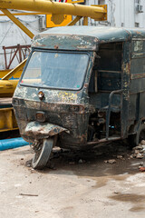 Fototapeta na wymiar Abandoned and rusted tuk-tuk or auto rickshaw on roadside in India