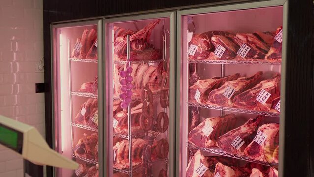 Beef steaks in dry aged meat aging in refrigerating cabinet. Dry aging meat in cold storage. Dry-aged cuts of raw meat, aged beef for steaks.