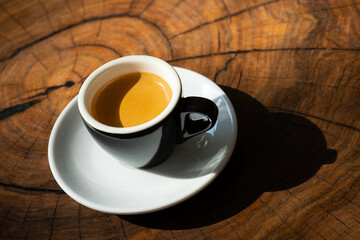 A cup of espresso on a wooden table.