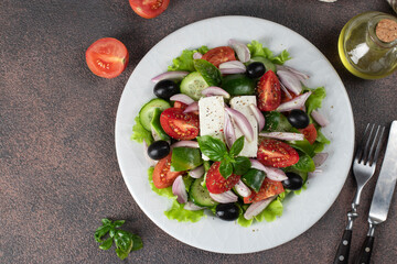 Classic Greek salad from tomatoes, cucumbers, sweet pepper, olives, basil and feta cheese
