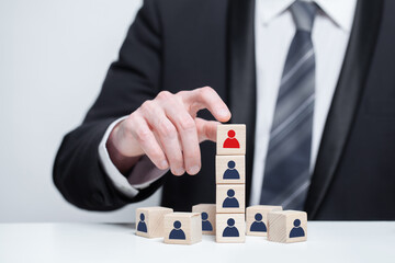 Wooden blocks with black and red people icons and businessman hands, leadership, carieer, teamwork...