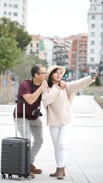 Happy multiracial couple of tourists taking a selfie together. Sightseeing in Madrid, Spain.
