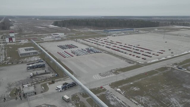 The new cars are lined up in the parking lot outside the production facility.