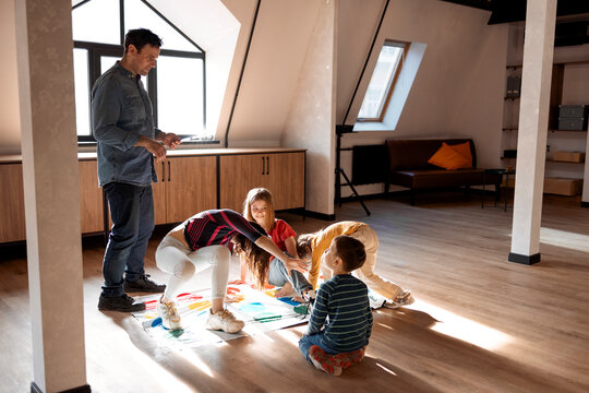 Kids With Father Playing Twister Game At Home. Family Activity