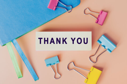 Thank you message on card for presentation, business. Note near notebook  and many colourful paper clips, top view. Business concept. Home Office.  Info concept Photos | Adobe Stock