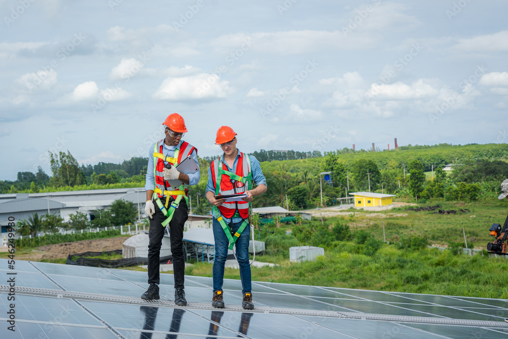 Poster technician wearing safety harness belt during installing the solar panels on roof structure of build