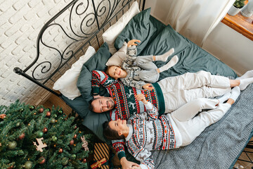 Happy family near fir-tree in bedroom, Christmas celebration at home