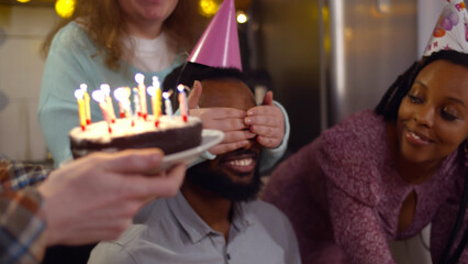 Group of friends meeting to celebrate man birthday at home surprising with cake