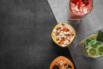 Many different delicious smoothies on grey table, flat lay. Space for text