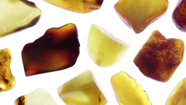 Amber rare jewel stones texture on half light white surface background. Moving right seamless loop backdrop.