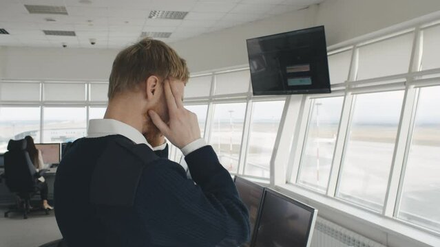 Air traffic control officer having headache working in airport tower. Realtime