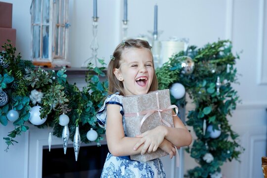 a girl sitting in a room with Christmas decoration