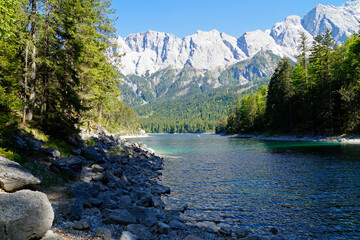 hiking trail overlooking picturesque turquois alpine lake Eibsee (yew lake) by the foot of mountain Zugspitze in Bavaria (the German Alps, Garmisch-Partenkirchen, Grainau, Bavaria, Germany)