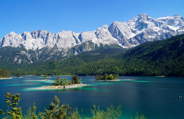 picturesque overgrown islands on turquois alpine lake Eibsee (yew lake) by the foot of mountain...