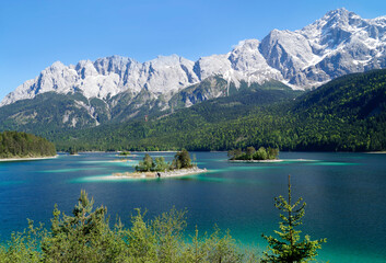 hiking trail overlooking picturesque turquois alpine lake Eibsee (yew lake) by the foot of mountain...