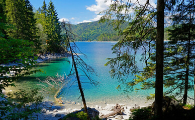 hiking trail overlooking picturesque turquois alpine lake Eibsee (yew lake) by the foot of mountain...