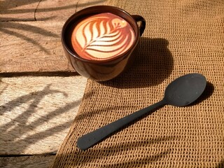 cup of coffee, spoon and sach on wood background 