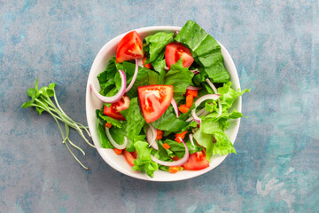 Healthy food leave lettuce vegetable salad has tomato in bowl on blue wood background.