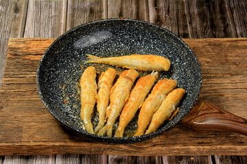 Fried small fish on a metal pan, Hamsa Turkish national cuisine