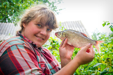 Large bream in women's hands. Girl on a fishing trip.