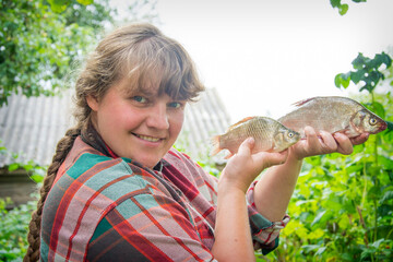 Large bream in women's hands. Girl on a fishing trip.