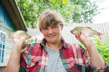 Large bream in women's hands. Girl on a fishing trip.
