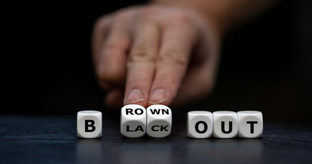 Hand turns dice and changes the expression 'blackout' to 'brownout'.