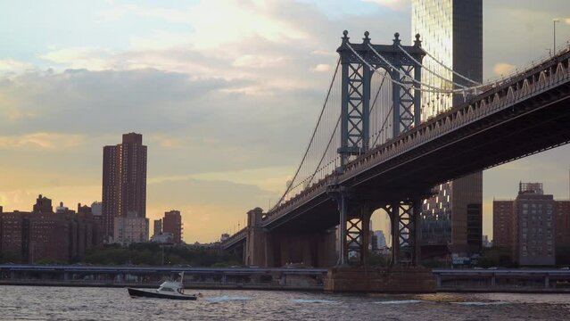 New York City, NY. USA - August 20, 2022: Manhattan Bridge at sunset seen from Pebble Beach, Brooklyn