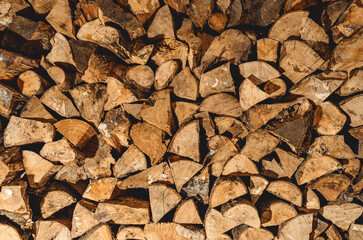 stack of neatly stacked firewood is dried under a canopy in the open air. Background for design. Cover.