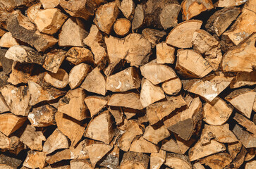 stack of neatly stacked firewood is dried under a canopy in the open air. Background for design. Cover.